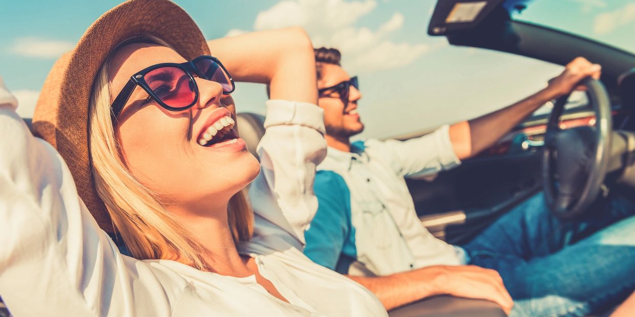 couple in convertible car driving and smiling having fun. www.rsivacations.com