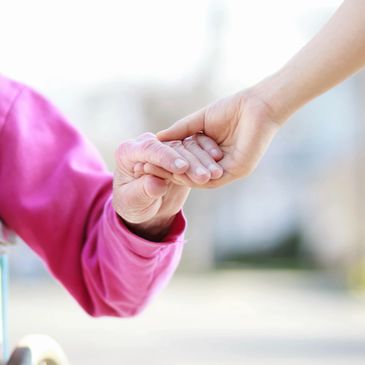 Helping hand holding hands with someone of limited mobility