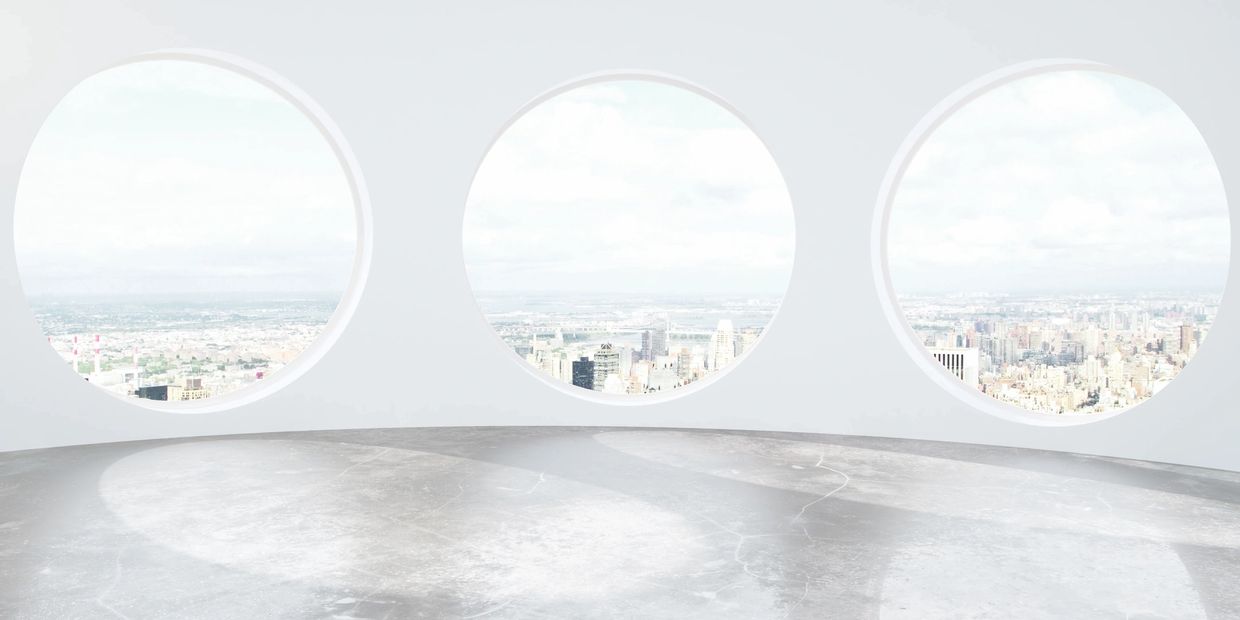 3 large circular windows in white room with gleaming floor overlooking the city below