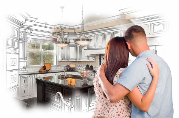 A happy couple embraces, while gazing on their kitchen, being renovated