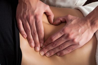 massage therapist hands on patient's back