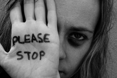 A image featuring women with 'Please stop' written on her hand.