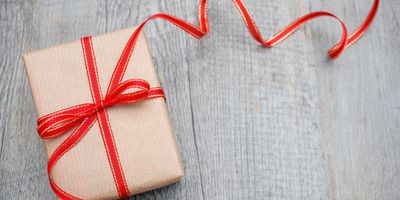 A neatly wrapped present conveying a sense of celebration or giving, includes a London tour voucher.