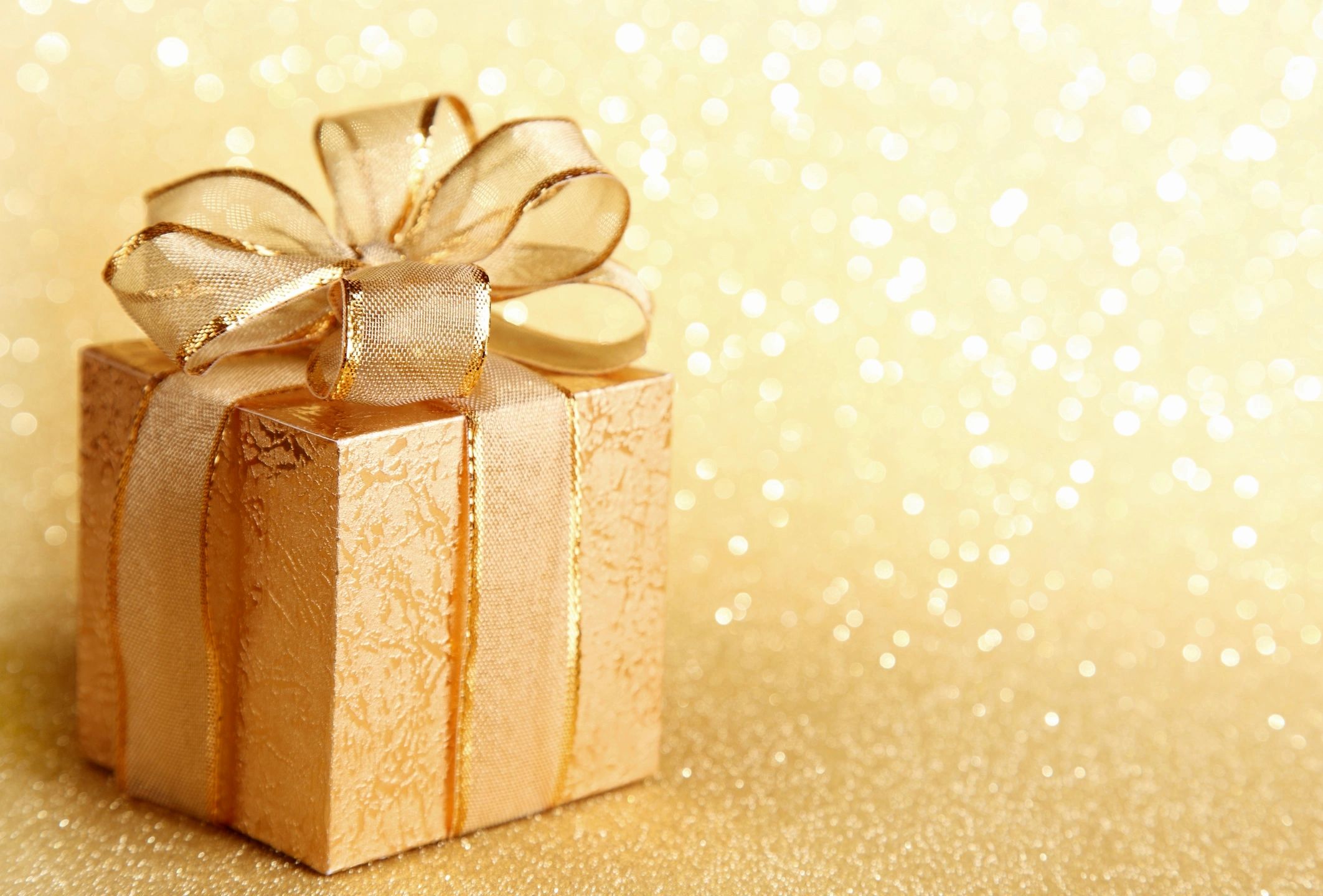 A gold present with a shiny golden background