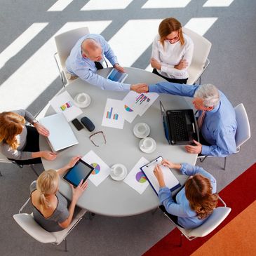 6 people having a meeting around a circular table