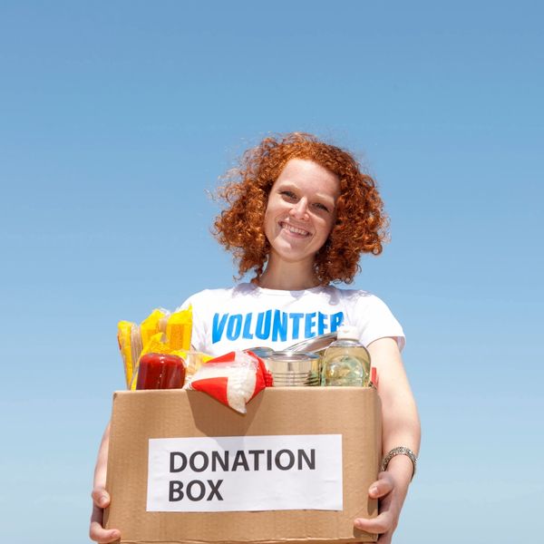 Girl with volunteer shirt and donation box for nonprofit