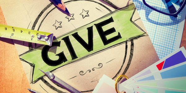 An eclectic style photograph of a piece of paper, saying the word "Give" surrounded by pencils