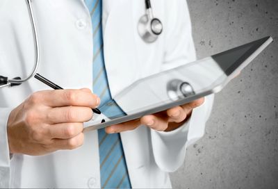 A doctor writing on a tablet
