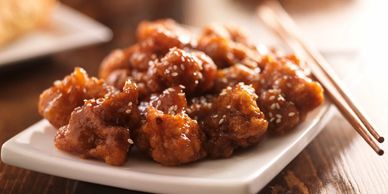 Orange chicken served with chopsticks after being delivered to your customers fresh and hot.