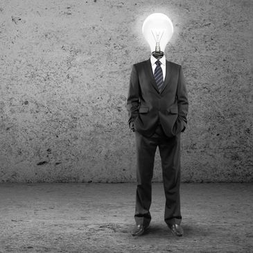 Man wearing a suit with a bright light bulb for a head, with a great idea for a Jingle.