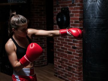 A female boxer punches the boxing bag