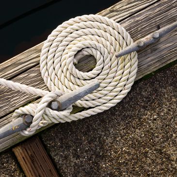 ropes tied to a cleat on a marina pier