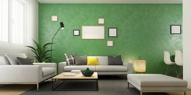 Green living room wall with a few picture frames hung on the wall