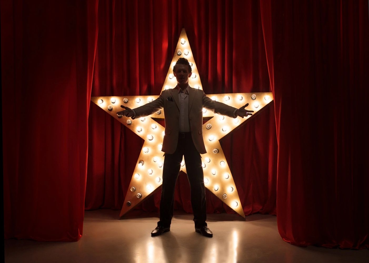 Actor on stage in front of star prop