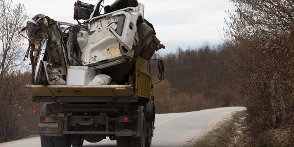 A truck filled with junk drives down the road