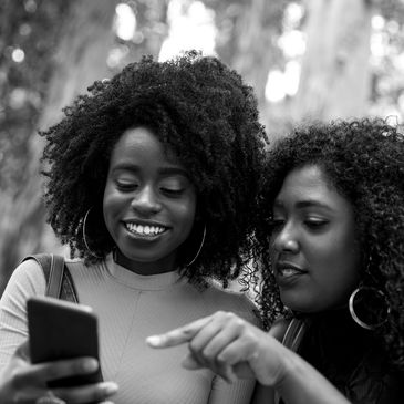 Two black women looking at a cell phone
