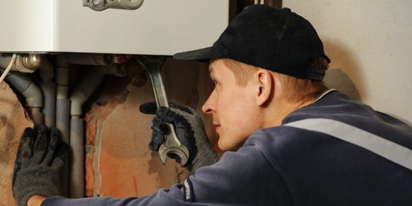 Plumber fixing gas boiler