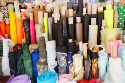 various rolls of fabric standing on end - various widths / various colors / various quantites 