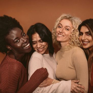 Four women of color hugging.