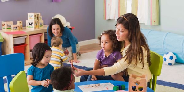 Teacher helping her children learn at day care