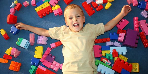 Preschooler child playing with colorful toy blocks