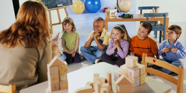 Children eager to learn in day care from their teacher