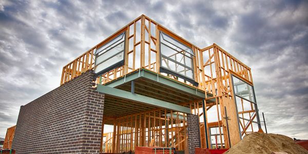 home build in progress with steel beams and dimensional lumber framing two story custom home