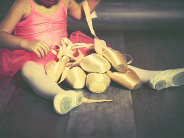 Kid playing with pointe shoes