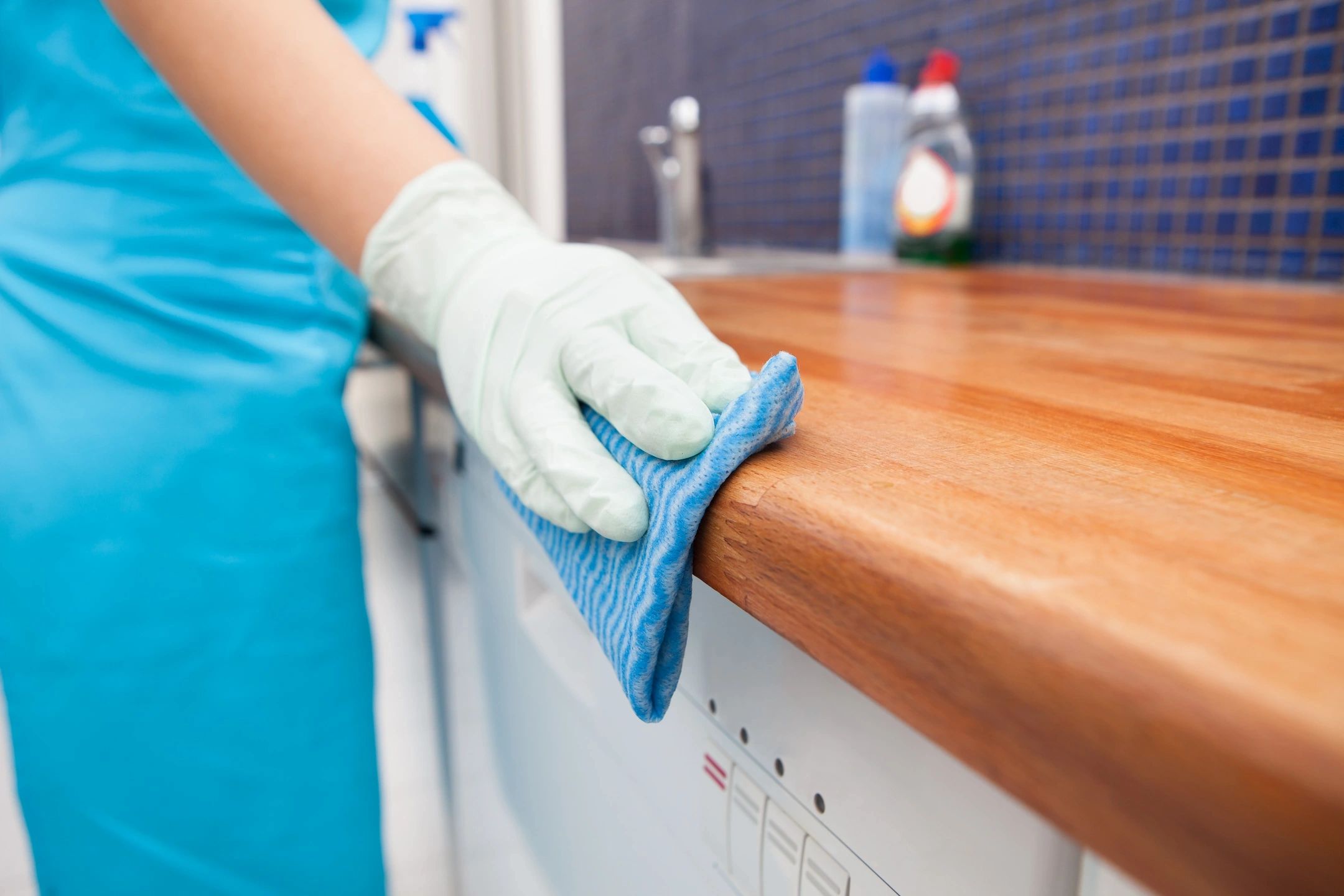 Person cleaning worktop bench