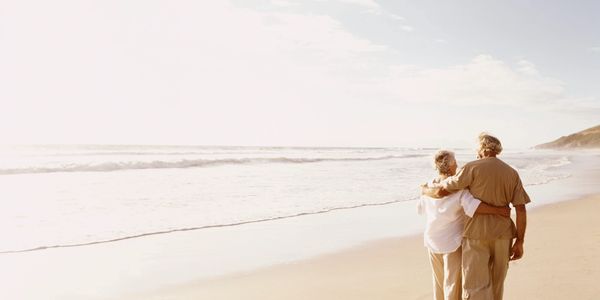 Elderly couple walking on a beautiful, serene beach