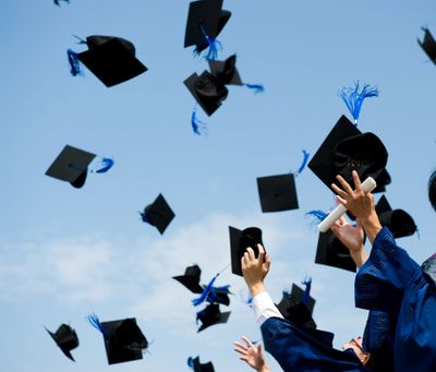 College students throwing graduation caps into the air