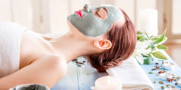 Women laying on a spa bed with a customized skin care face mask.