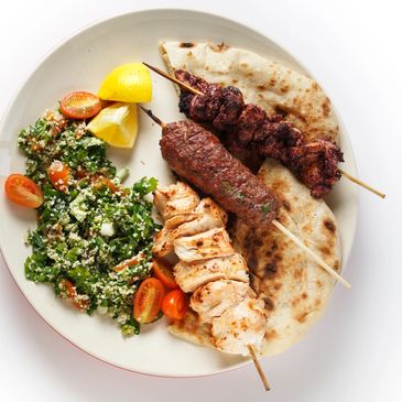 Combo plate with Shish Taouk chicken skewer, lamb Kafta kebab skewer, tabbouli, hummus and pita