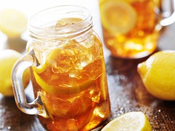 Mason jar glass with freshly brewed iced tea and lemons