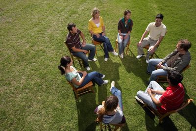 Group of people sitting on chairs arranged in a circle.