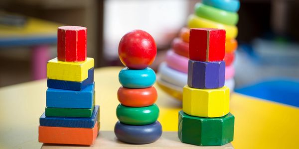 Children's stacking toy with more toys in the blurred background