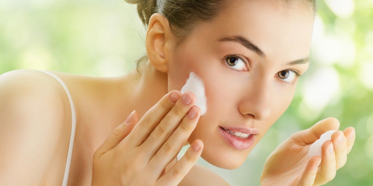 Woman applying cleansing foam to her face
