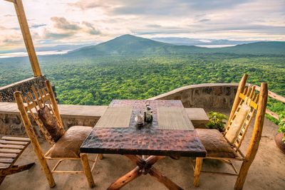 Dinner tble and chairs overlooking African landscape.