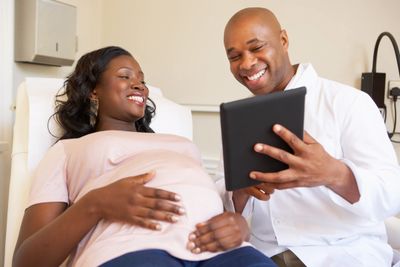 Smiling African American couple looking at an image of their baby on ultrasound.