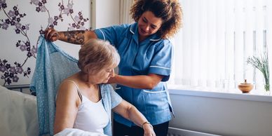 Home Care caregiver helping older woman get dressed