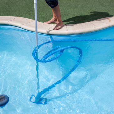 Pool maintenance, someone vacuuming a pool