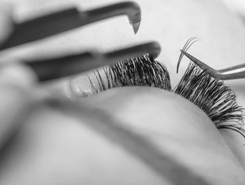 Close up of eyelash extensions and tweezers