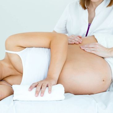 Pregnant women getting pain relief from massage therapy