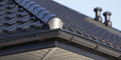 Image of a black roof that focuses on the clean gutters.