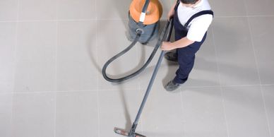 Man vacuum a floor.