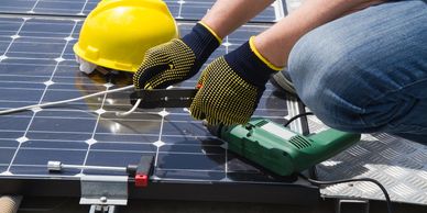 A man using tools and working on solar panels