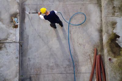 aerial view of a man pressure washing concrete 