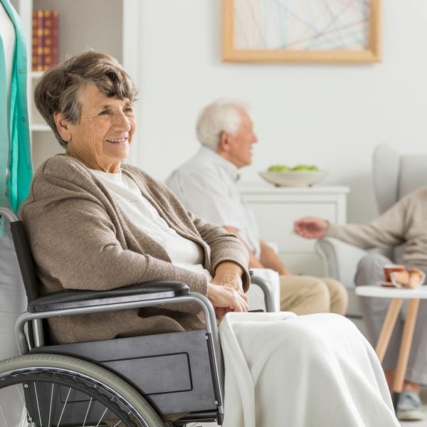 Caregiver assisting an elderly client in her wheelchair