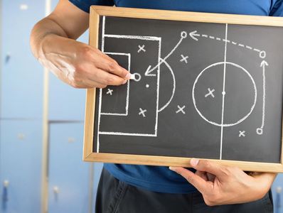 A person showing a football tactics board with line and crosses on