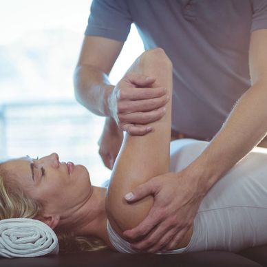 An osteopathic manual therapy session in a clinical setting, featuring a female practitioner